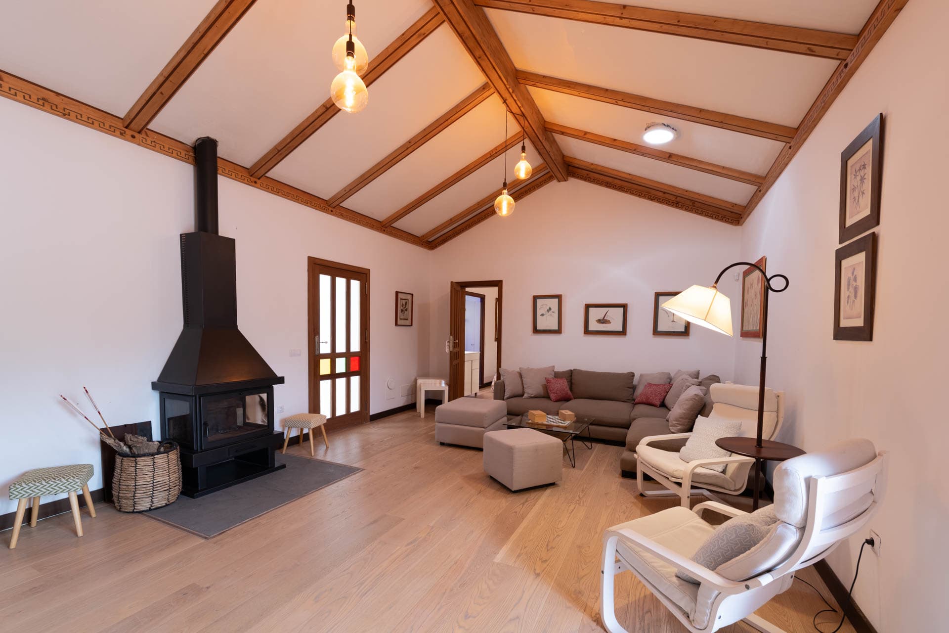 Rincón del salón chimenea en Finca Anconito con textiles cálidos